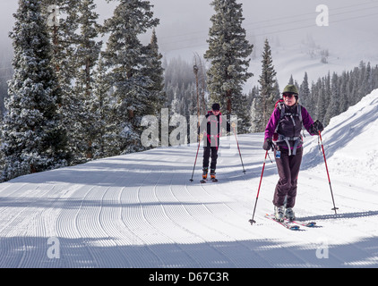 L'homme et de la femme de l'écorcher montée sur skis de randonnée alpine au Monarch Mountain, Continental Divide, Colorado, USA Banque D'Images