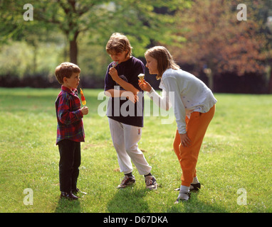 Les enfants de manger des glaces en jardin, Sunninghill, Berkshire, Angleterre, Royaume-Uni Banque D'Images