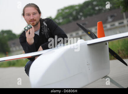 Fichier - Un fichier photo datée du 27 juin 2012 montre d'assistant de recherche à l'Institut de systèmes aérospatiaux à l'Université technique de Braunschweig Karl Kufieta présentant un micro aérien et une unité de commande de pilote automatique à Braunschweig, en Allemagne. Micro-avions sont de plus en plus utilisés pour des missions de surveillance et de reconnaissance. Un congrès international le 03 juillet 2012 Banque D'Images