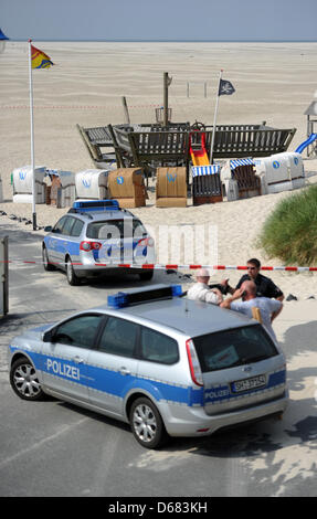 Les agents de police et les voitures de police sont devant le 'bateau pirate' escalade où Sebastian a été vu pour la dernière fois sur Wittduen Amrum, Allemagne, 04 juillet 2012. Le garçon de dix ans a disparu le dimanche de déclencher une recherche policière intensive. Photo : DANIEL REINHARDT Banque D'Images