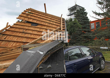 Les employés de service de remorquage de voiture Une voiture de récupération des débris d'un toit à Memmingen, Allemagne, 06 juillet 2012. De fortes pluies avaient emporté le toit d'un bâtiment administratif à l'aéroport de Memmingen, qui ensuite endommagé plusieurs voitures. Photo : Karl-Josef Opim Banque D'Images