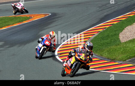 Cavalier allemand Sandro Cortese du Team Red Bull KTM mène la course Moto3 d'avance sur le français Alexis MASBOU et coureur espagnol Luis Salom l'équipe de RW Racing GP au cours de l'allemand au Sachsenring MotoGP à Hohenstein-Ernstthal, Allemagne, 08 juillet 2012. Photo : JAN WOITAS Banque D'Images