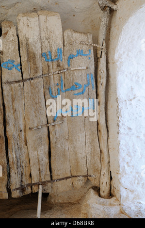 La vieille porte de bois lourd à l'entrée d'un cavehouse troglodytique Matmata Tunisie Banque D'Images
