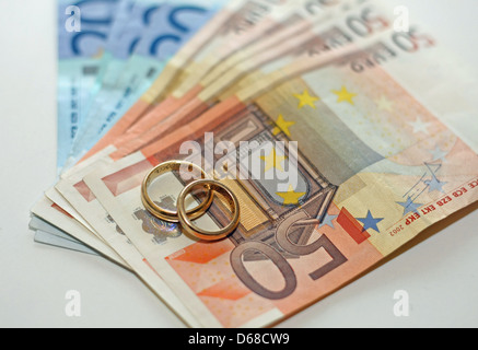 L'argent et les billets en euros avec deux anneaux de mariage en or sont au-dessus de la pile Banque D'Images