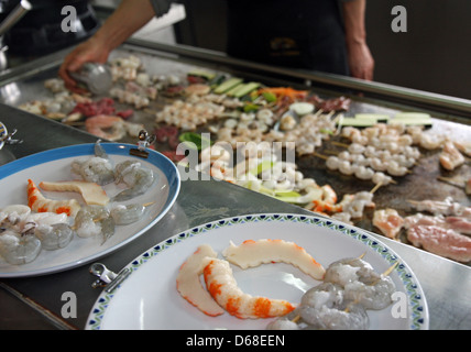 Cuire en chinois il fait cuire des légumes et de la viande de poisson dans la grille chaude Banque D'Images