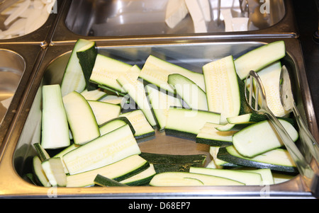 Les courgettes et les tranches de courgette dans le restaurant prêt à être grillées sur le gril Banque D'Images