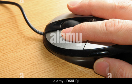 Main d'un jeune adulte qui cliquez sur le bouton gauche de la souris à l'index Banque D'Images