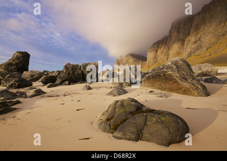 Roches sur une plage de sable et de falaises côtières sur l'île de Vaeroy sur les îles Lofoten en Norvège Banque D'Images