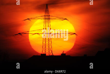 (Dossier) une archive photo datée du 06 février 2012 montre le soleil derrière un mât d'alimentation près de Laatzen, Allemagne. Un débat sur le redressement de l'énergie à l'ordre du jour de la clôture de la séance plénière de juillet semaine au parlement de Basse Saxe. Photo : Julian Stratenschulte Banque D'Images