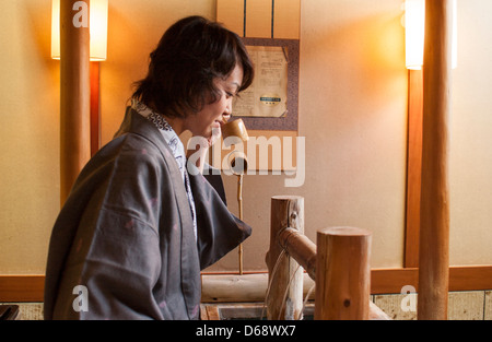Un invité prend une gorgée d'eau minérale à l'hôtel à Shoju Onsen Shima, la préfecture de Gunma, Japon Banque D'Images