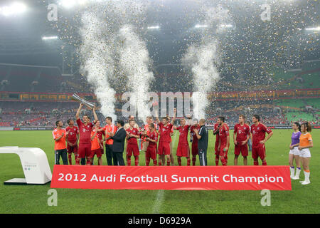 Daniel van Buyten de Munich (3-L) cheers avec la coupe après le test match de la Bundesliga allemande clubs de football du VfL Wolfsburg vs FC Bayern Munich à Guangzhou, Chine, le 26 juillet 2012. Photo : Roland Hermstein Banque D'Images