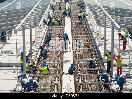 Les travailleurs de la construction pose des rails de chemin de fer pour les nouveaux tramways dans Al Sufouh Dubaï Émirats Arabes Unis Banque D'Images