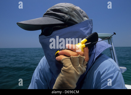 Guide de pêche les pourparlers sur un téléphone cellulaire à Marathon dans les Florida Keys Banque D'Images