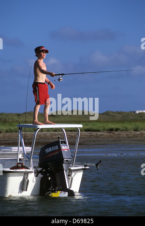 Jeune garçon de pêche à la truite mouchetée et le sébaste à partir d'un bateau près de Port Aransas Texas Banque D'Images