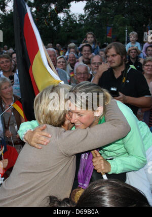 Champion Olympique de concours complet de l'équipe Sandra Auffarth (avant-R) est embrassé par sa mère pendant son Auffarth Baerbel Bienvenue chez sa famille dans l'école d'Ganderkesee, Allemagne, 03 août 2012. Fans, amis et famille a donné les 25 ans un accueil chaleureux. Auffarth sur son cheval Opgun Louvo avait remporté une médaille d'or en concours complet de l'équipe et une médaille de bronze en concours complet individuel à l'Olympi Londres Banque D'Images