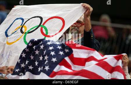 Un spectateur peut contenir jusqu'le drapeau olympique à côté d'un drapeau américain dans la région de North Greenwich Arena au les Jeux Olympiques de 2012 à Londres, Londres, Grande-Bretagne, 7 août 2012. Photo : Friso Gentsch dpa Banque D'Images