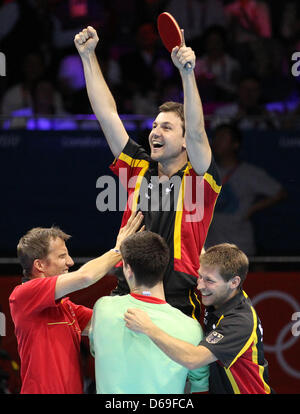 Le joueur de tennis de table Timo Boll (haut) célèbre avec ses coéquipiers Bastian Steger (R), Dimitrij Ovtcharov (C) et l'entraîneur Joerg Rosskopf (L) après avoir remporté la médaille de bronze chez les hommes team match contre Hong Kong dans ExCeL Arena au les Jeux Olympiques de 2012 à Londres, Londres, Grande-Bretagne, 08 août 2012. Photo : Friso Gentsch dpa. Photo : Friso Gentsch dpa  + + +(c) afp - Bildfunk + + + Banque D'Images