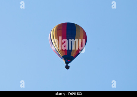 Ballon à air chaud de couleur vive contre un ciel bleu Banque D'Images