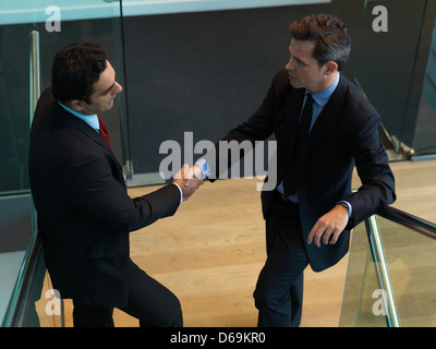 Businessmen shaking hands in office Banque D'Images
