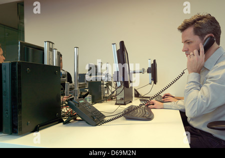 Businessman talking on phone at desk Banque D'Images