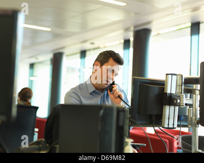 Businessman talking on phone at desk Banque D'Images