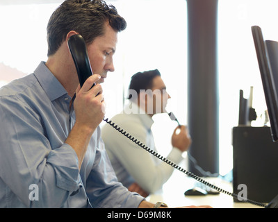 Businessman talking on phone at desk Banque D'Images