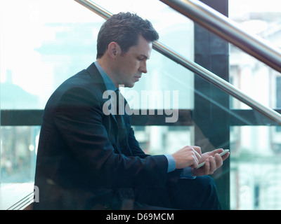 Businessman using cell phone in office Banque D'Images