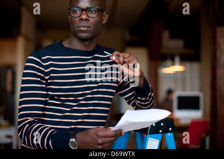 Businessman reading papers in office Banque D'Images