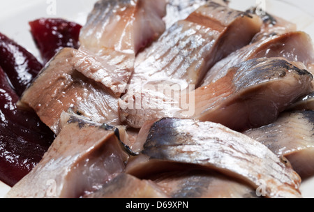 Filet de hareng salé frais brillant avec du caviar et de l'huile sur la plaque. Macro photo Banque D'Images
