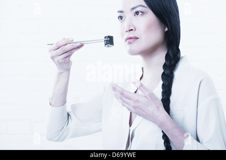 Woman smelling morceau de sushi Banque D'Images