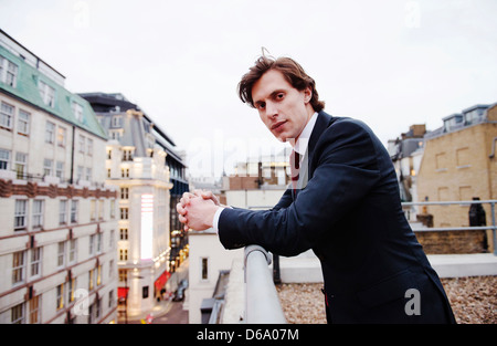 Businessman standing on urban rooftop Banque D'Images