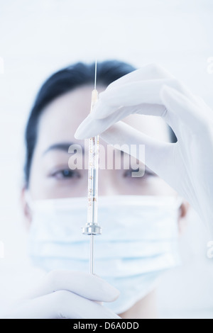 Doctor examining syringe Banque D'Images