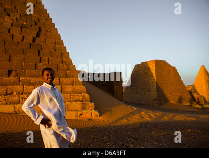 Les jeunes Soudanais en face des pyramides et des tombes dans le cimetière royal, Méroé, Soudan Banque D'Images