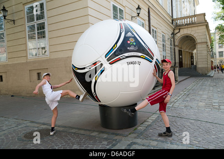 Lviv, Ukraine, les garçons posant contre un modèle surdimensionné de l'adidas Tango 12 Banque D'Images