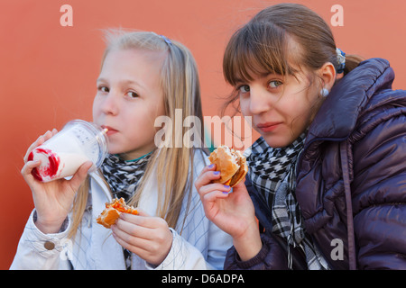 Les adolescentes de manger un hamburger Banque D'Images