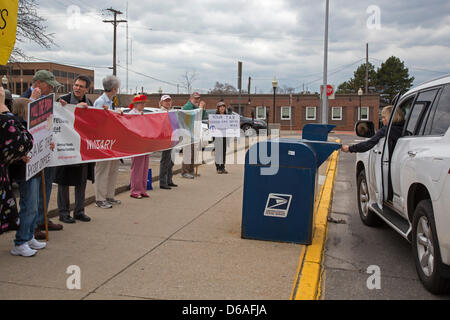 Royal Oak, Michigan - Membres de Peace Action du Michigan rassemblement devant la Royal Oak bureau de poste en tant que citoyens quittent leurs déclarations d'impôt. Ils réclament une réduction des dépenses du Pentagone, et l'augmentation des investissements dans les villes, les soins de santé, et la réparation des routes. Leur bannière représente le pourcentage des dépenses militaires dans le budget discrétionnaire des États-Unis. Banque D'Images