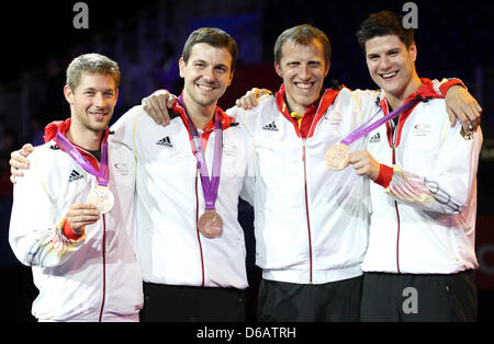 Allemagne (L-R) Bastian Steger, Timo Boll, entraîneur Joerg Rosskopf et Dimitrij Ovtcharov célébrer leurs médailles de bronze lors de la cérémonie de remise des médailles pour l'équipe masculine de tennis de table dans ExCeL à l'arène pour les Jeux Olympiques de 2012 à Londres, Londres, Grande-Bretagne, 08 août 2012. Photo : Friso Gentsch dpa  + + +(c) afp - Bildfunk + + + Banque D'Images