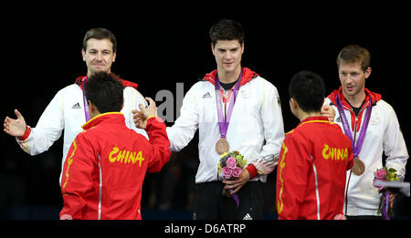 Allemagne (L-R) de Timo Boll, Dimitrij Ovtcharov et Bastian Steger célèbrent leurs médailles de bronze lors de la cérémonie de remise des médailles pour l'équipe masculine de tennis de table dans ExCeL à l'arène pour les Jeux Olympiques de 2012 à Londres, Londres, Grande-Bretagne, 08 août 2012. Photo : Friso Gentsch dpa  + + +(c) afp - Bildfunk + + + Banque D'Images