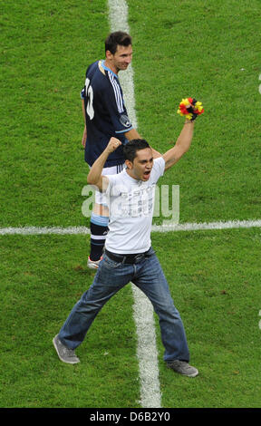 L'Argentine Lionel Messi (L) sourire alors qu'il regarde une jubilating fan sur le terrain pendant le match de football de l'Allemagne contre l'Argentine à la Commerzbank-Arena à Francfort/Main, Allemagne, 15 août 2012. Photo : Frank Kleefeldt dpa dpa  + + +(c) afp - Bildfunk + + + Banque D'Images