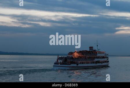 Les gens s'assoient sur un navire ossature un statue de la Vierge Marie à Lindau, Allemagne, 15 août 2012. Cinq bateaux avec environ 4 000 personnes ont assisté à la 31e Fatima procession en bateau sur le lac de Constance à l'occasion de l'Assomption de la Sainte Vierge Marie au ciel. Photo : Karl-Josef Opim Banque D'Images