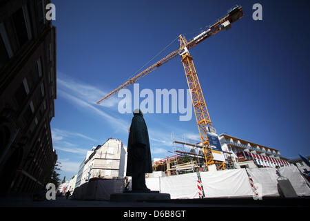 Une statue d'Adam Opel se tient juste en face de l'entrée de l'usine Opel en face d'un site la construction du à l'aide d'une grue à Rüsselsheim, Allemagne, 23 août 2012. Constructeur automobile Opel est en crise et est maintenant en tirant sur la rupture d'urgence : des milliers d'employés sera défini sur le chômage partiel à partir de septembre. Opel ne peut plus se permettre le cher capacités excédentaires. Photo : FRED Banque D'Images