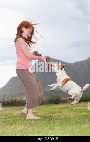 Girl Playing with dog in grass Banque D'Images