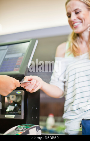 Femme de payer par carte de crédit en magasin Banque D'Images