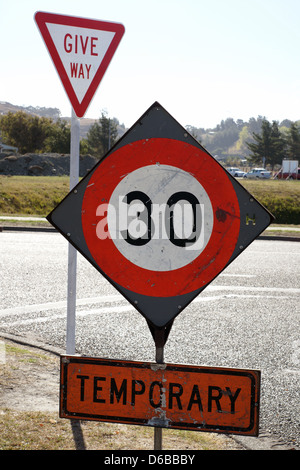 Limite de vitesse temporaire de 30 km/h et faire place à un panneau routier urbain junction en Nouvelle Zélande Banque D'Images