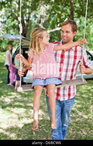 Père fille poussant on swing Banque D'Images