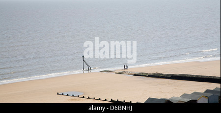 Les gens qui marchent sur une large plage de sable vide à Frinton and on Sea, Essex, Angleterre Banque D'Images