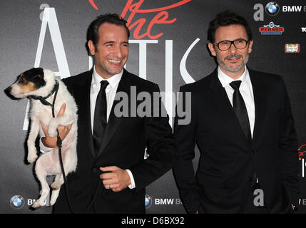 L'acteur français Jean Dujardin (L) avec un chien et le réalisateur Michel Hazanavicius posent sur le tapis rouge au cinéma Delphi Palace à l'occasion de la première allemande du film 'l'artiste' à Berlin, Allemagne, 03 janvier 2012. Le film va commencer à montrer dans les salles allemandes le 26 janvier 2012. Le noir et blanc film muet est l'une des est un candidat sérieux pour le Golden Globe. Banque D'Images