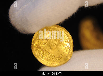 Un archéologue présente une pièce d'or marqué avec le roi mérovingien Theudebert à la chancellerie d'État à Potsdam, Allemagne, 05 janvier 2012. La médaille, c'est le plus précieux de tous les résultats dans la région Uckermark. Huit pièces d'or, qui font partie d'un trésor byzantin, ont été trouvés dans la région Uckermark en novembre 2011. 200 pièces d'or de la même origine ont été trouvés dans les 19t Banque D'Images