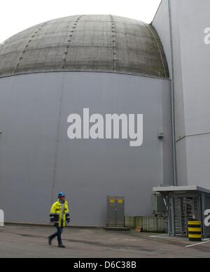 Les membres du personnel à pied passé la centrale nucléaire désaffectée dans Obrogheim, Allemagne, 11 janvier 2012. Obrigheim centrale a été désaffectée en 2005 et est maintenant soumis à la deuxième phase de démantèlement, qui comprend l'enlèvement des matériaux contaminés. Photo : Uwe Anspach Banque D'Images