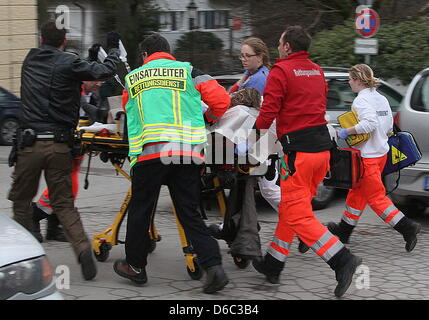 Les ambulanciers et les agents de police apportent un état gravement blessé à l'ambulance, l'avocat à Dachau, Allemagne, 11 janvier 2012. Un homme de 54 ans tiré de l'état d'un procureur lors du procès au tribunal de district à Dachau le 11 janvier 2012. Le délai de 31 ans est décédé à l'hôpital après une opération d'urgence. Photo:Niels P. Joergensen Banque D'Images